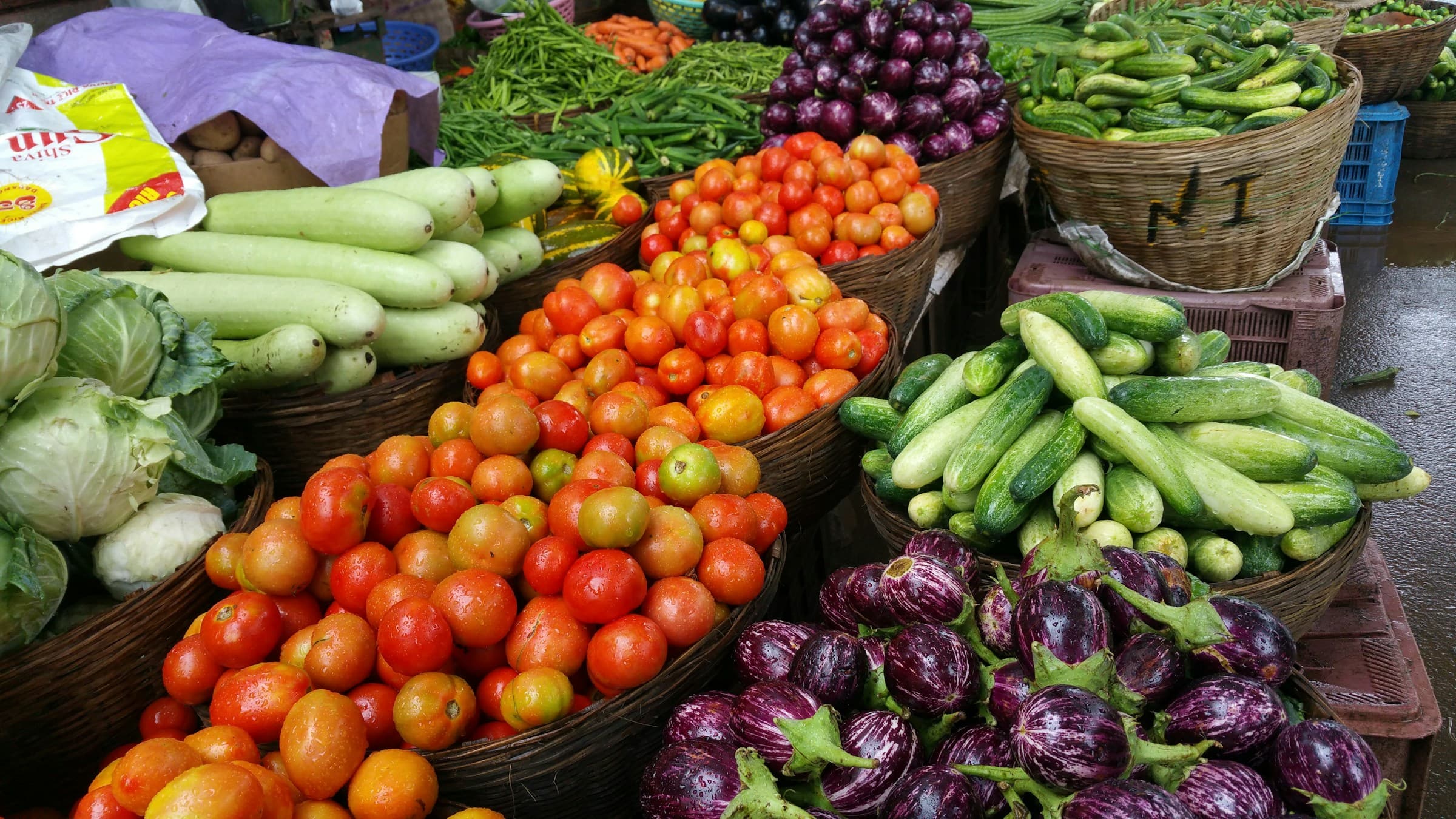 Fresh vegetables displayed in baskets at a local shop